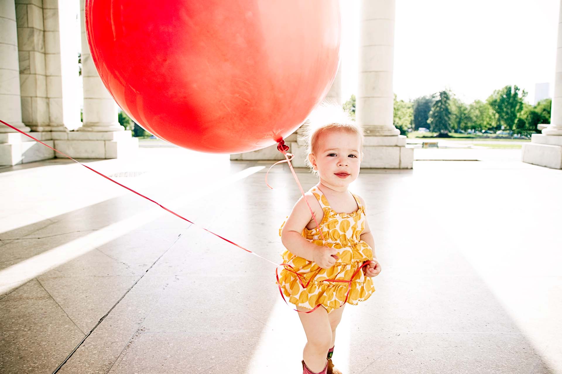 Marianne with her big balloon at her family portrait photography session in Cheesman Park